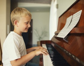 Boy in white shirt playing piano