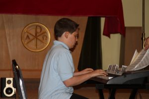 Boy in blue shirt playing piano